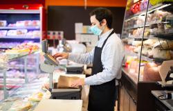 Shopkeeper with mask in Italian deli 