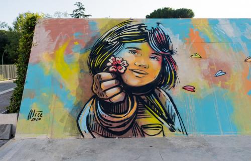 Wall painted by the artist with a little girl who give a flower