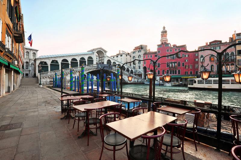 empty tables by the Rialto bridge in Venice