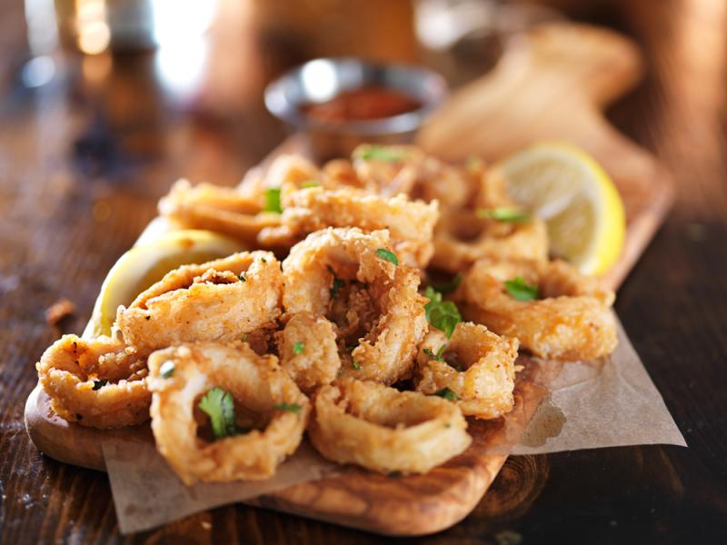 Fried calamari with lemon wedges and herbs