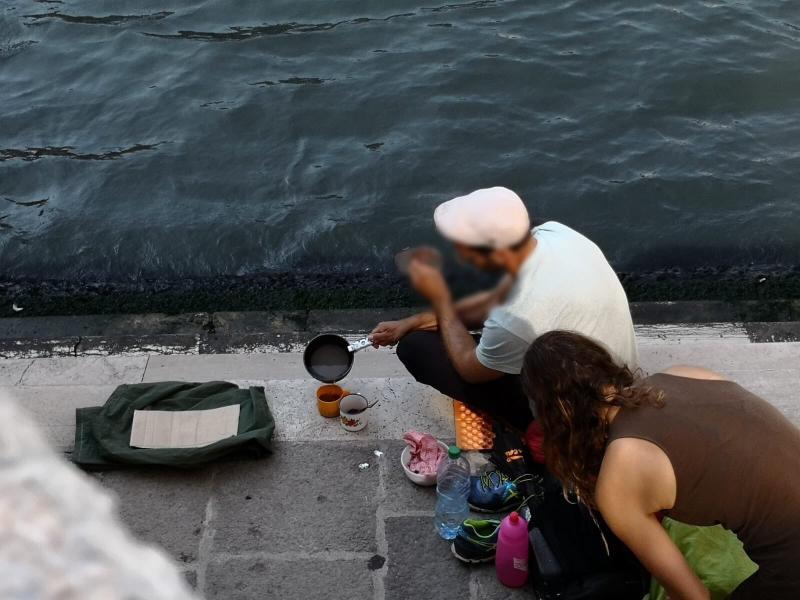 German tourists in Venice make coffee at Rialto Bridge by Grand Canal